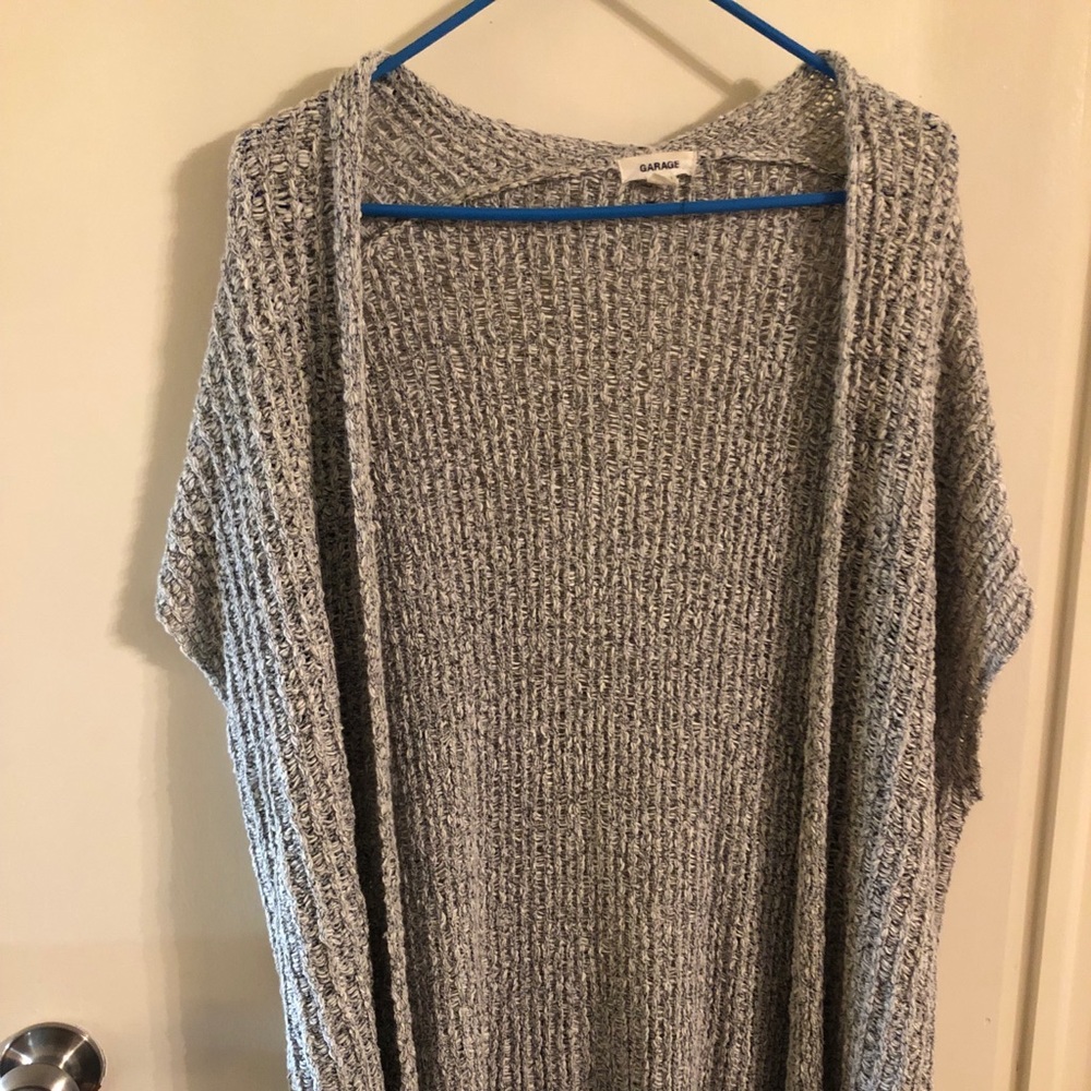 Gray sleeveless open front sweater.